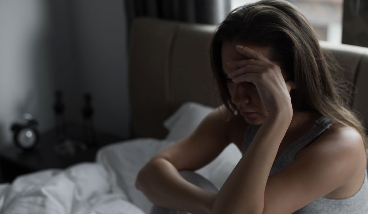 sad woman sitting on her bed